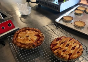 Image of Strawberry-Rhubarb Pies​ from cooking class at Sur La Table with pre-baked tart shells in the background ready to be filled